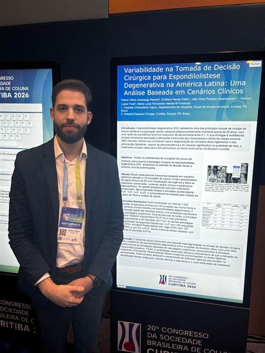 Dr. Otávio Vitório ao lado de pôster científico sobre espondilolistese degenerativa, no 20º Congresso da Sociedade Brasileira de Coluna
